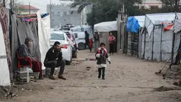 Meskipun dalam kondisi yang sangat sulit dan terbatas, setelah terhentinya pendidikan formal selama lebih dari dua tahun akibat perang antara Israel dan Hamas. Tampak dalam foto, seorang gadis kecil berjalan ke sekolah di Deir al-Balah, di Jalur Gaza tengah, pada 10 Desember 2025. (BASHAR TALEB/AFP)