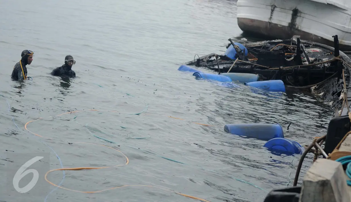 Petugas Basarnas dan Pol air mengamati proses pengangkatan bangkai kapal Zahro Express di Pelabuhan Muara Angke, Jakarta, Rabu (4/1). Pengangkatan kapal yang mulai tenggelam itu menggunakan drum kosong yang diisi helium. (Liputan6.com/Gempur M Surya)