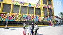 Sejumlah warga berjalan di dekat karya seni Mural di Taman Ismail Marzuki (TIM), Cikini, Jakarta, Selasa (11/9). Mural tersebut dibuat oleh seniman asal Kolombia Diana Ordonez. (Liputan6.com/Faizal Fanani)
