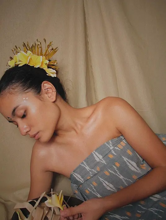 Pada foto ini Winda terlihat tampil totalitas bergaya bak gadis tradisional Bali. Rambutnya disanggul dengan hiasan bunga dan aksesoris khas Bali. Tanpa riasan berlebih, wajahnya tampak sehat dan cantik natural. (Instagram/arawindak)