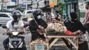 Pedagang melayani pembeli ketupat matang di jalan kawasan Rawamangun, Jakarta, Senin (19/7/2021). Jelang Hari Raya Idul Adha, pedagang ketupat matang atau siap saji musiman mulai ramai menjajakan makanan khas Lebaran tersebut di pinggir jalan kawasan Rawamangun. (merdeka.com/Iqbal S. Nugroho)