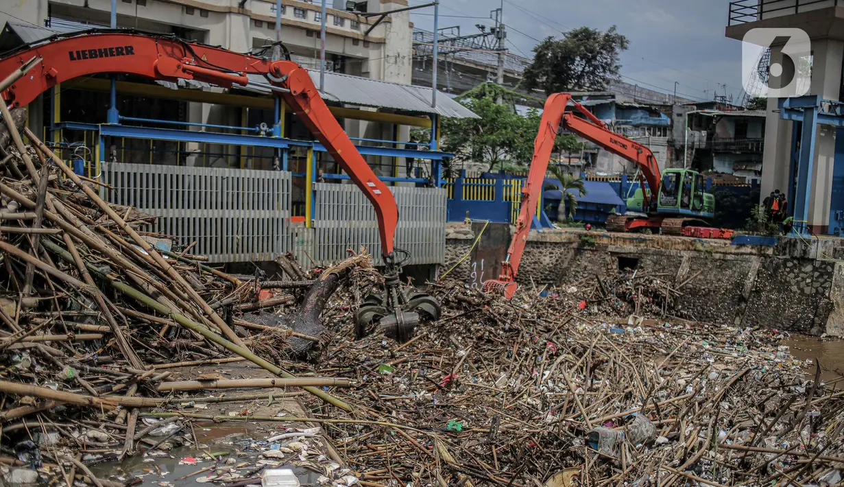 Pekerja kebersihan mengangkat sampah yang menumpuk di pintu air Manggarai, Jakarta, Selasa (22/9/2020). Tingginya curah hujan membuat kiriman sampah menumpuk di pintu air Manggarai. (Liputan6.com/Faizal Fanani)