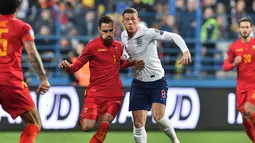 Duel antara Ross Barkley dengan Marko Vesovic pada laga kedua Kualifikasi Piala Eropa 2020 yang berlangsung di Stadion Pod Goricom, Podgrica, Selasa (26/3). Timnas Inggris menang 5-1 atas Montenegro. (AFP/Andrej Isakovic)