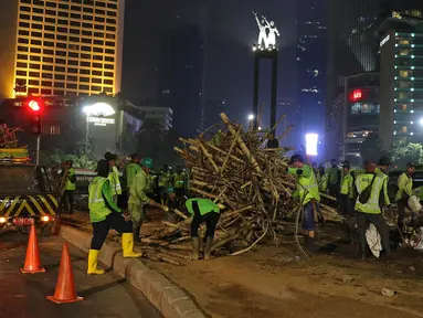 Petugas Dinas Kehutanan DKI Jakarta membongkar instalasi bambu Getah Getih di Bundaran Hotel Indonesia (HI), Kamis (18/7/2019) dini hari. Karya seni tersebut rencananya akan diganti dengan taman dan setelah dibongkar, bambu itu akan dibawa ke tempat pembuangan sampah. (Liputan6.com/Herman Zakharia)