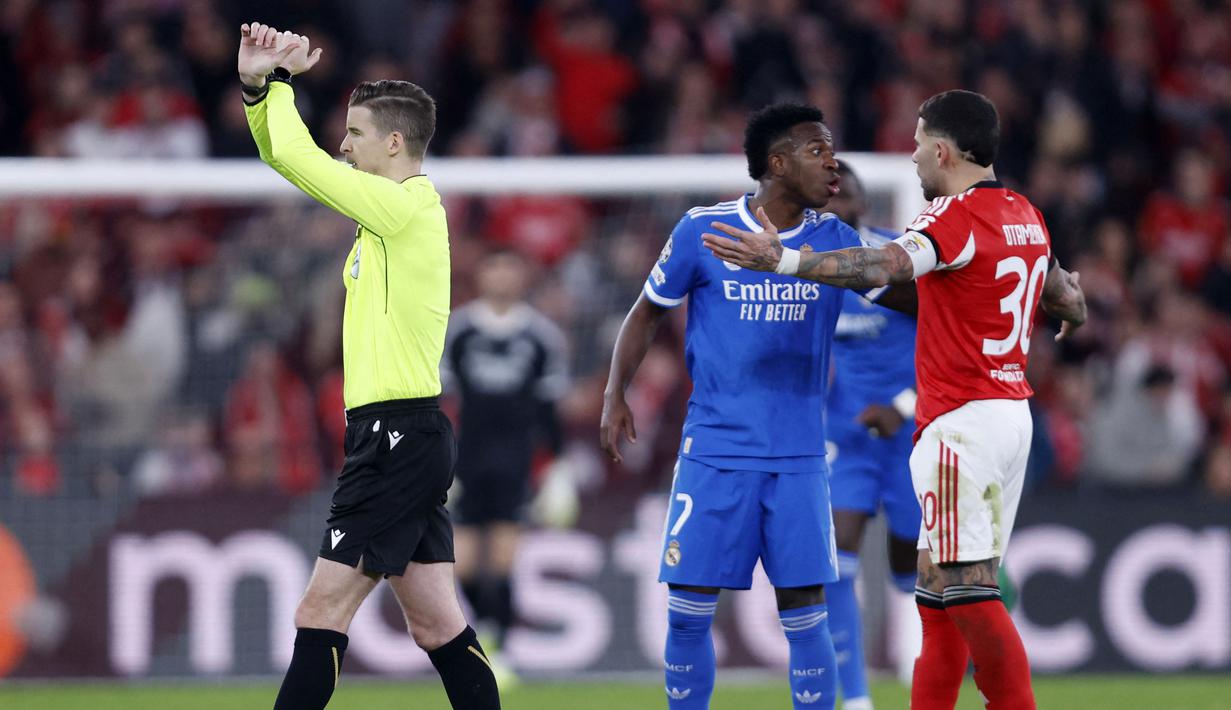 Laga bahkan sempat dihentikan 10 menit saat Vinicius berlari menghampiri wasit Letexier. Penjelasan sang pemain, wasit asal Prancis, Francois Letexier, u membuat gestur tangan menyilang, tanda resmi diaktifkannya protokol anti-rasisme yang resmi dikenalkan FIFA sejak Mei 2024. (AFP/Filipe Amorim)