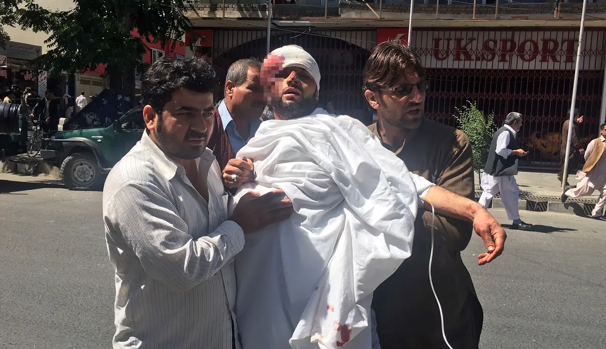 Warga mengevakuasi orang yang terluka setelah serangan bom bunuh diri di Kabul, Afganistan, (31/5). Bom ini menewaskan Sedikitnya sembilan orang dan melukai puluhan orang. (AP Photos / Massoud Hossaini)
