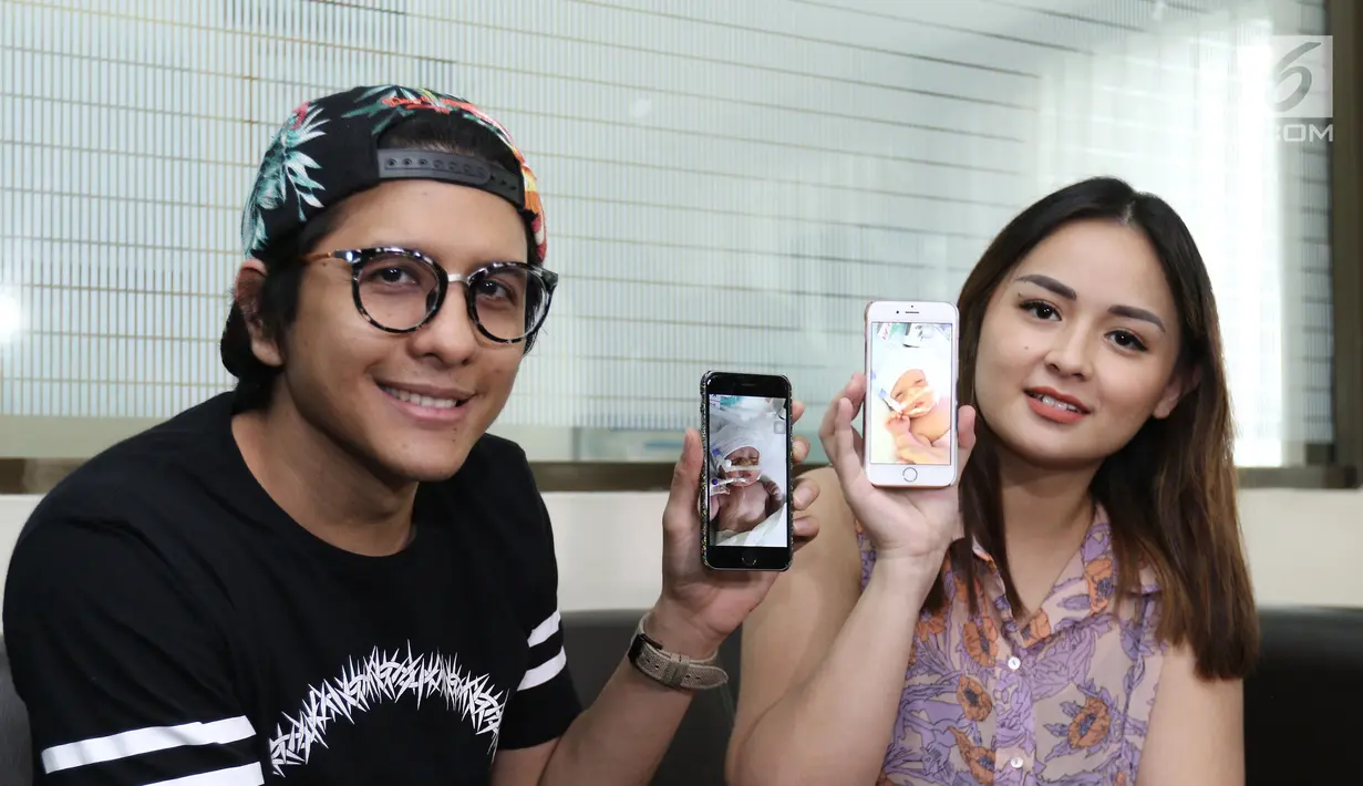 Pasangan Joanna Alexandra dan Raditya menunjukkan foto anak ke 4 nya, Jakarta, Selasa (30/5). Joanna melahirkan anak ke empat yang diberi nama Ziona Eden Alexandra Panggabean. (Liputan6.com/Herman Zakharia)