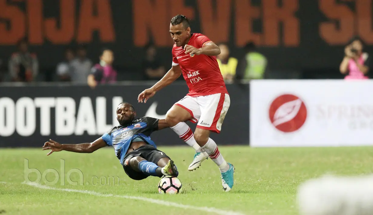 Pemain Madura United, Engelberd Sani menghalau bola dari kaki pemain Persija Jakarta, Bruno Lopes pada lanjutan Liga 1 2017 di Stadion Patriot, Bekasi, Kamis (4/5/2017). Persija kalah dari Madura 0-1. (Bola.com/Nicklas Hanoatubun)