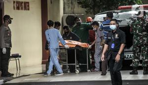 Tim forensik menurunkan kantong jenazah berisi serpihan Sriwijaya Air SJ 182 dan diduga tubuh korban dari ambulans di RS Polri, Jakarta, Minggu (10/1/2021). RS Polri menerima tiga kantong jenazah berisi serpihan pesawat dan diduga tubuh korban untuk diidentifikasi. (merdeka.com/Iqbal S. Nugroho)