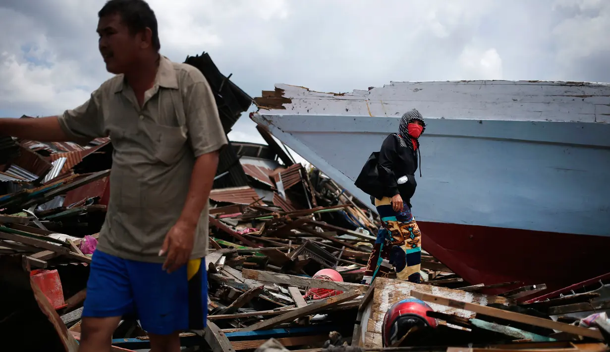 Seorang pria dan wanita mencari barang-barang di mana rumah mereka berdiri sebelum gempa dan tsunami di desa Wani, Palu, Kamis (4/10). Gempa bumi berkekuatan 7,4 skala richter melanda Palu dan Donggala pada 28 September 2018 lalu. (AP/Dita Alangkara)