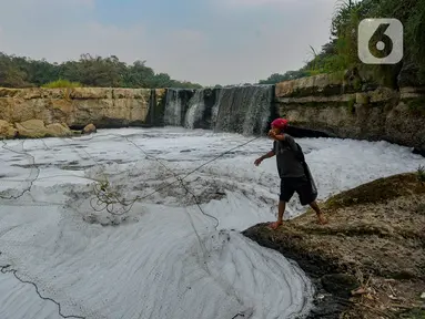 Warga menjala ikan pada Kali Cileungsi yang merupakan hulu Kali Bekasi yang tercemar limbah pabrik di kawasan Angsana, Gunung Putri, Bogor, Minggu (27/08/2023). (merdeka.com/Arie Basuki)