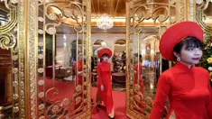 Pegawai bersiap untuk menyambut para tamu di lobi hotel Dolce Hanoi Golden Lake yang baru saja diresmikan di Hanoi, Vietnam pada Kamis (2/7/2020). Hotel tersebut merupakan hotel berlapiskan emas 24 karat pertama di dunia. (Manan VATSYAYANA / AFP)