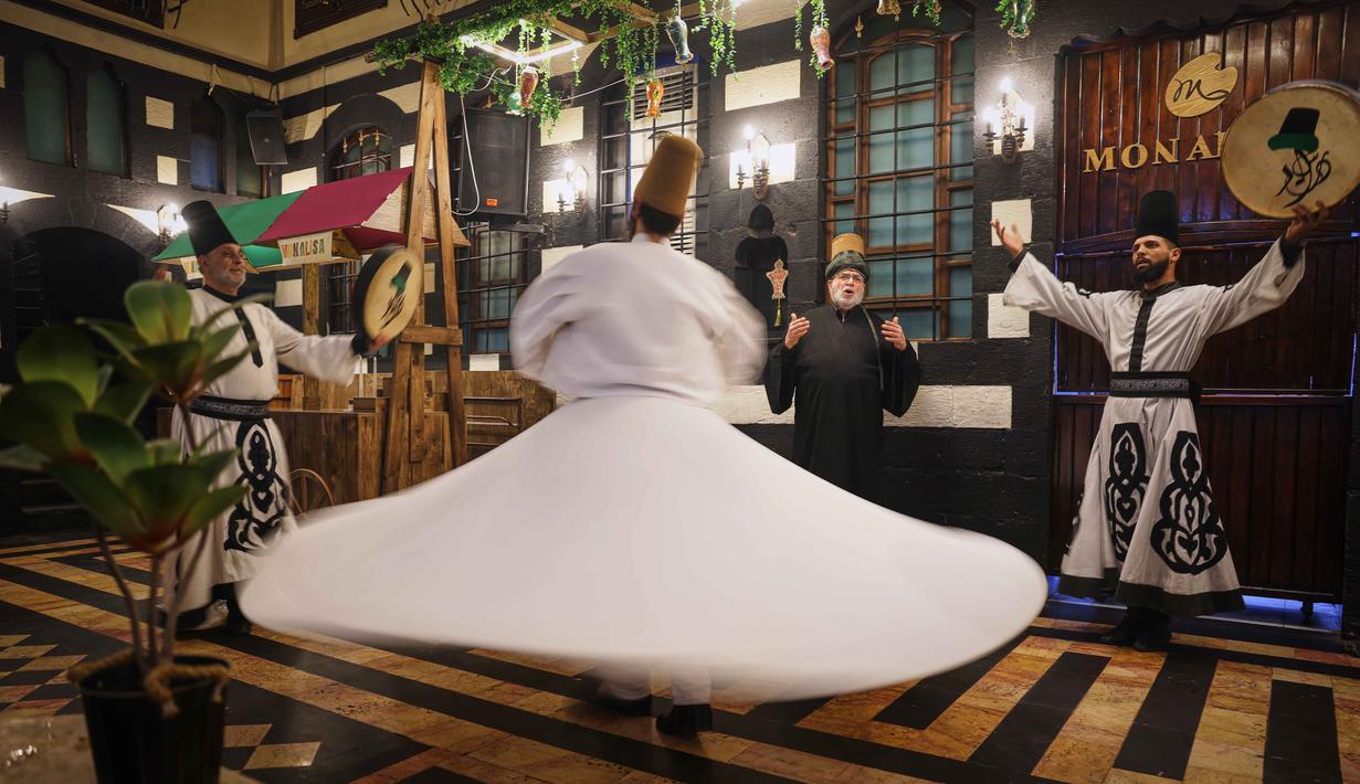 Para penari berputar menampilkan tarian Sufi di sebuah restoran selama pertunjukan yang diadakan setelah berbuka puasa selama bulan suci Ramadan 1447 Hijriah, di distrik bersejarah Damaskus, Suriah, Minggu 22 Februari 2026. (AP Photo/Ghaith Alsayed)
