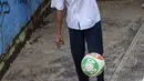 Seorang anak bermain sepak bola dalam bak truk di kawasan Cengkareng, Jakarta, Rabu (23/2/2022). Minimnya lahan bermain di kawasan tersebut membuat anak-anak memanfaatkan tempat yang bukan semestinya untuk bermain bola. (Liputan6.com/Johan Tallo)