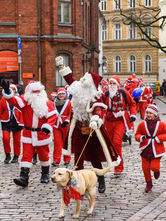 Peserta mengambil bagian dalam Santa's Fun Run di Riga, Latvia, Minggu (8/12/2019). Ini merupakan acara amal yang pesertanya bersenang-senang dengan berlari atau berjalan kaki sambil mengenakan kostum Sinterklas untuk mengumpulkan dana bagi anak-anak di rumah sakit Latvia. (Gints Ivuskans/AFP)