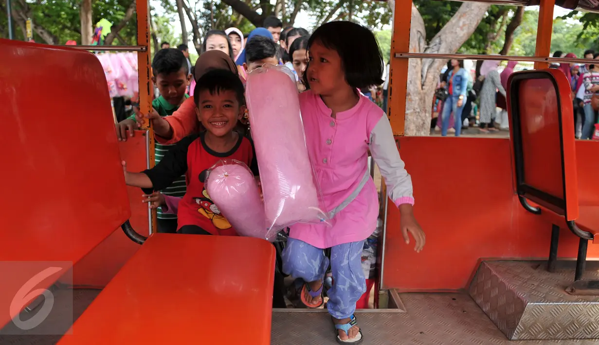 Sejumlah anak menaiki mobil gandeng di kawasan Monas, Jakarta, Sabtu (26/12/2015). Libur Natal dimanfaatkan sejumlah warga untuk berwisata ke tempat yang menjadi ikon Jakarta tersebut. (Liputan6.com/Yoppy Renato)