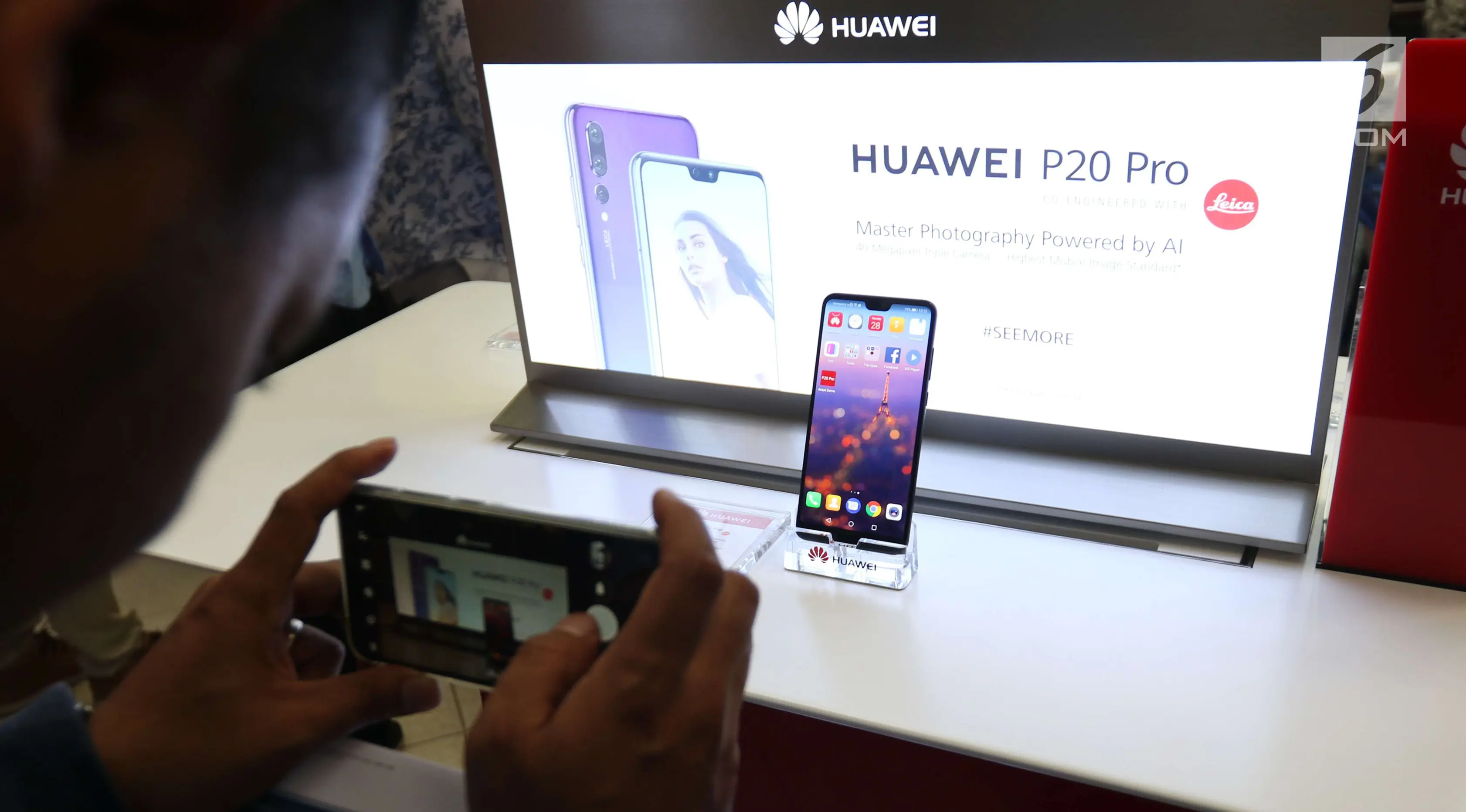 Seorang pengunjung mengabadikan ponsel Huawei P20 Pro di Jakarta, Kamis (28/6). Huawei P20 Pro resmi dipasarkan dan dibanderol seharga Rp 11.999.000 di Indonesia. (Liputan6.com/Angga Yuniar)
