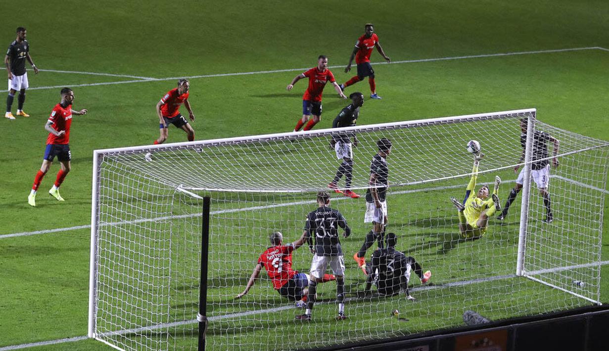 Kiper Manchester United, Dean Henderson, melakukan penyelamatan saat melawan Luton Town pada Piala Liga Inggris di Stadion Kenilworth Road, Rabu (23/9/2020). Setan Merah menang dengan skor 3-0. (Cath Ivill/Pool via AP)