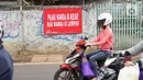 Pengendara motor melintas di depan poster protes warga terhadap pembangunan flyover di kawasan Tanjung Barat, Jakarta, Rabu (15/7/2020). Dalam poster protes tersebut, warga menuntut agar pembayaran pelunasan pembebasan lahan segera diselesaikan secara serentak. (Liputan6.com/Immanuel Antonius)