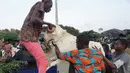 Orang-orang menaikkan domba, yang dibeli untuk perayaan Idul Adha, ke atas kendaraan di sebuah pasar kawasan Abidjan, Pantai Gading, Jumat (17/8). Dalam Perayaan Idul Adha, umat islam di seluruh dunia akan menyembelih hewan ternak. (AFP/ISSOUF SANOGO)