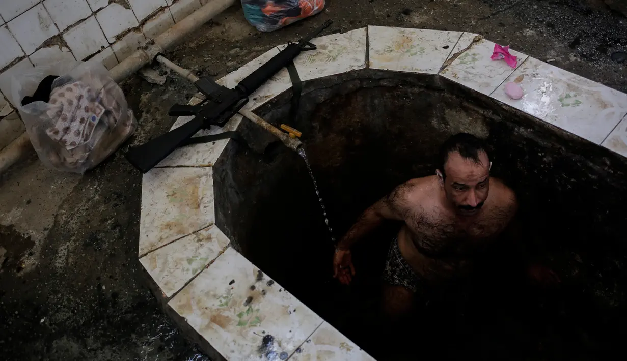 Petugas kepolisian Irak menikmati kolam renang air hangat dari belerang di Hamam Alli, Mosul, Irak, (27/4). (AP Photo/Bram Janssen)