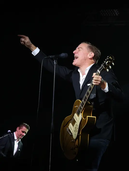 Penampilannya sungguh menakjubkan malam itu, terlebih dengan setelan jas berwarna hitamnya Bryan Adams semakin terlihat gagah. Rasa lelah sepertinya tak melekat di dirinya saat itu karena melihat penonton yang membludak. (Bambang E. Ros/Bintang.com)