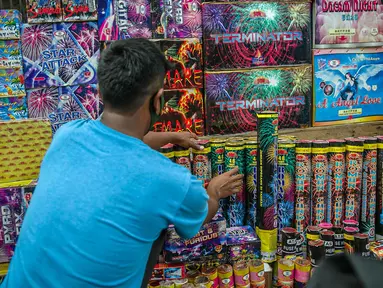 Seorang pedagang menata kembang api di Pasar Asemka, Jakarta, Selasa (29/12/2020). Sejumlah pedagang menyatakan, jelang perayaan Tahun Baru 2021 ini penjualan kembang api mengalami penurunan 75 persen dari tahun lalu. (Liputan6.com/Faizal Fanani)