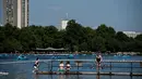 Sejumlah warga berenang saat suhu musim panas mencapai sekitar 28 derajat di Hyde Park di London, Inggris (5/7). (AFP Photo/Chris J Ratcliffe)