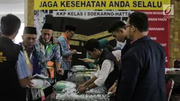 Panitia Penyelenggara Ibadah Haji (PPIH) memberikan perlengkapan untuk calon jemaah haji kloter pertama di Asrama Haji, Jakarta, Sabtu (6/7/2019). Sebelum diberangkatkan, petugas mengecek kembali 385 calon jamaah untuk melakukan kelengkapan administrasi. (Liputan6.com/Faizal Fanani)