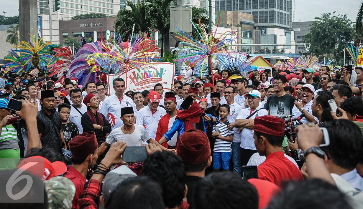Aksi pendekar Betawi saat membawakan tradisi Palang Pintu dalam acara Hajatan Bank DKI saat Car Free Day di kawasan Bundaran HI Jakarta, Minggu (16/10). Hajatan Bank DKI ini digelar dalam bentuk karnaval kebudayaan Betawi. (Liputan6.com/Faizal Fanani)
