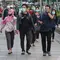 Sejumlah orang berjalan di trotoar pada saat jam pulang kantor di Kawasan Sudirman, Jakarta, Senin (8/6/2020). Aktivitas perkantoran dimulai kembali pada pekan kedua penerapan Pembatasan Sosial Berskala Besar (PSBB) transisi pandemi COVID-19. (Liputan6.com/Johan Tallo)