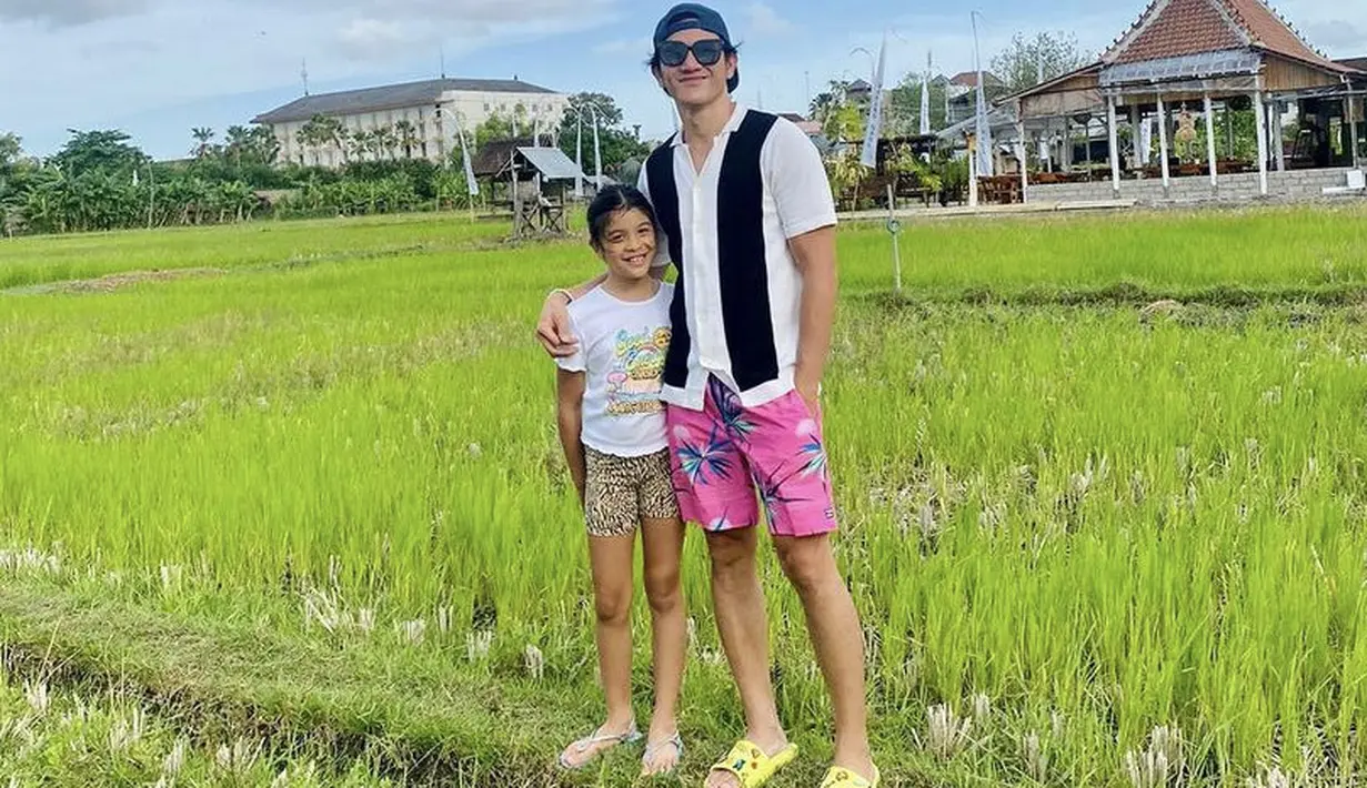 <p>Bersama sang ayah, Jizzy tampil santai mengenakan tshirt putih dan short pants bermotif dengan sandalnya saat berfoto background sawah.&nbsp;&nbsp;@vinogbastian__</p>