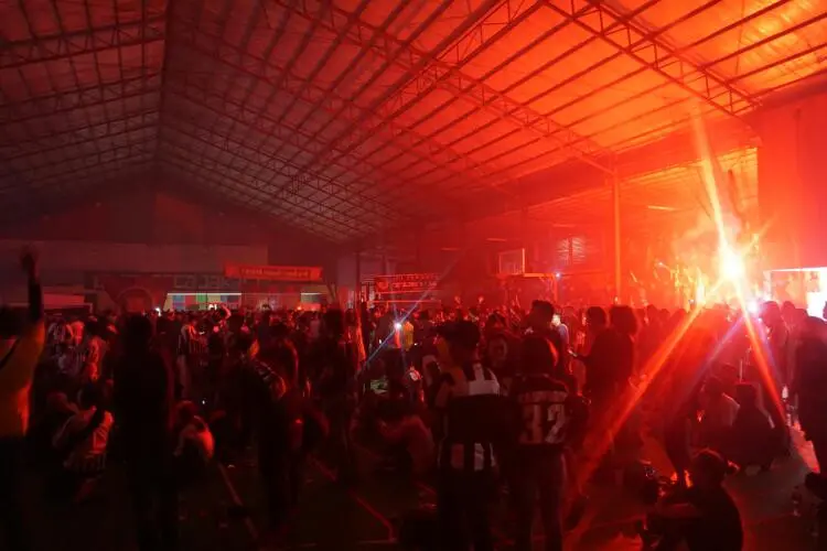 Suasana tempat nonton bareng yang seperti stadion karena adanya pendkung yang membawa suar api. (Bola.com/Nadhio Andromeda)