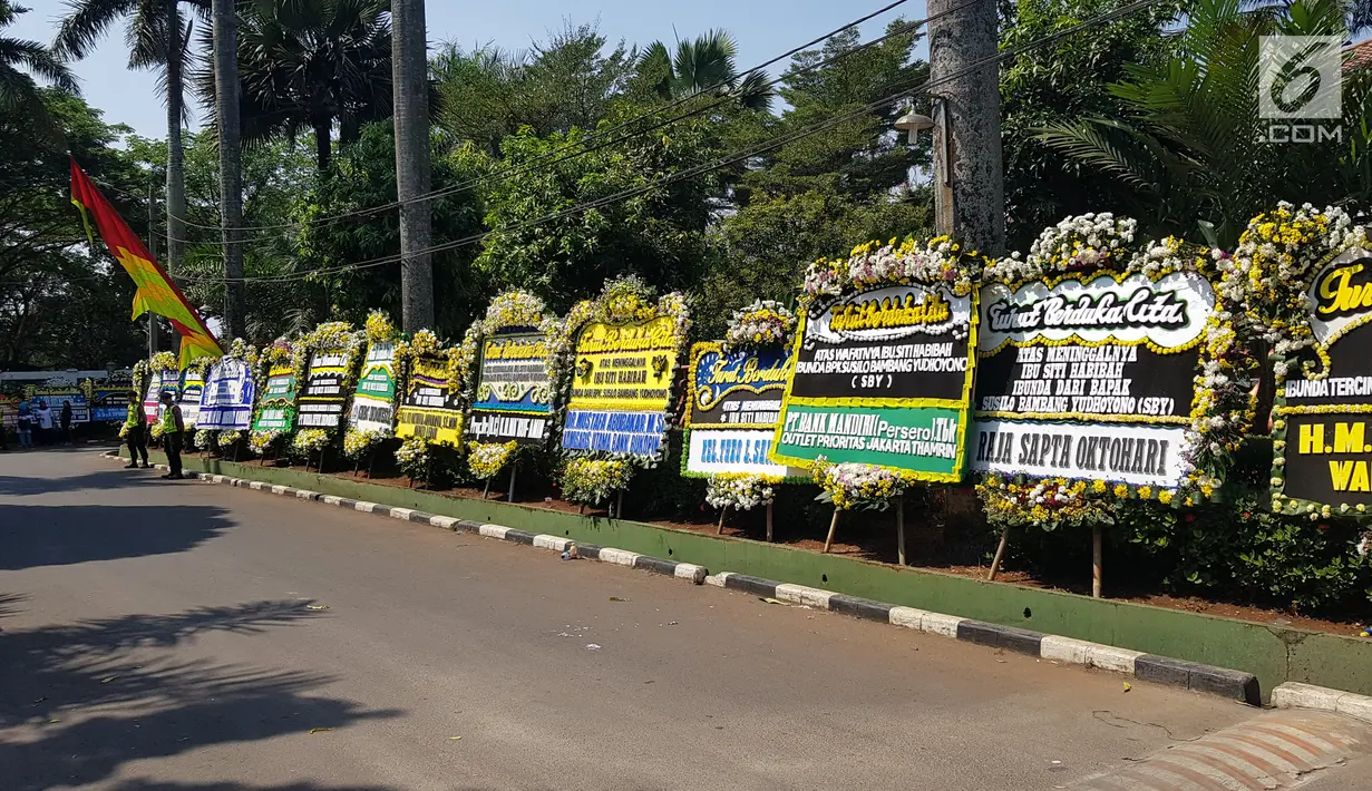 Polisi bediri dekat karangan bunga untuk almarhumah Siti Habibah, Ibunda Presiden ke-6 RI, Susilo Bambang Yudhoyono (SBY) di Puri Cikeas, Bogor, Sabtu (31/8/2019). Karangan bunga duka cita berdatangan di Puri Cikeas menyusul meninggalnya ibunda SBY pada Jumat (30/8). (Liputan6.com/Herman Zakharia)
