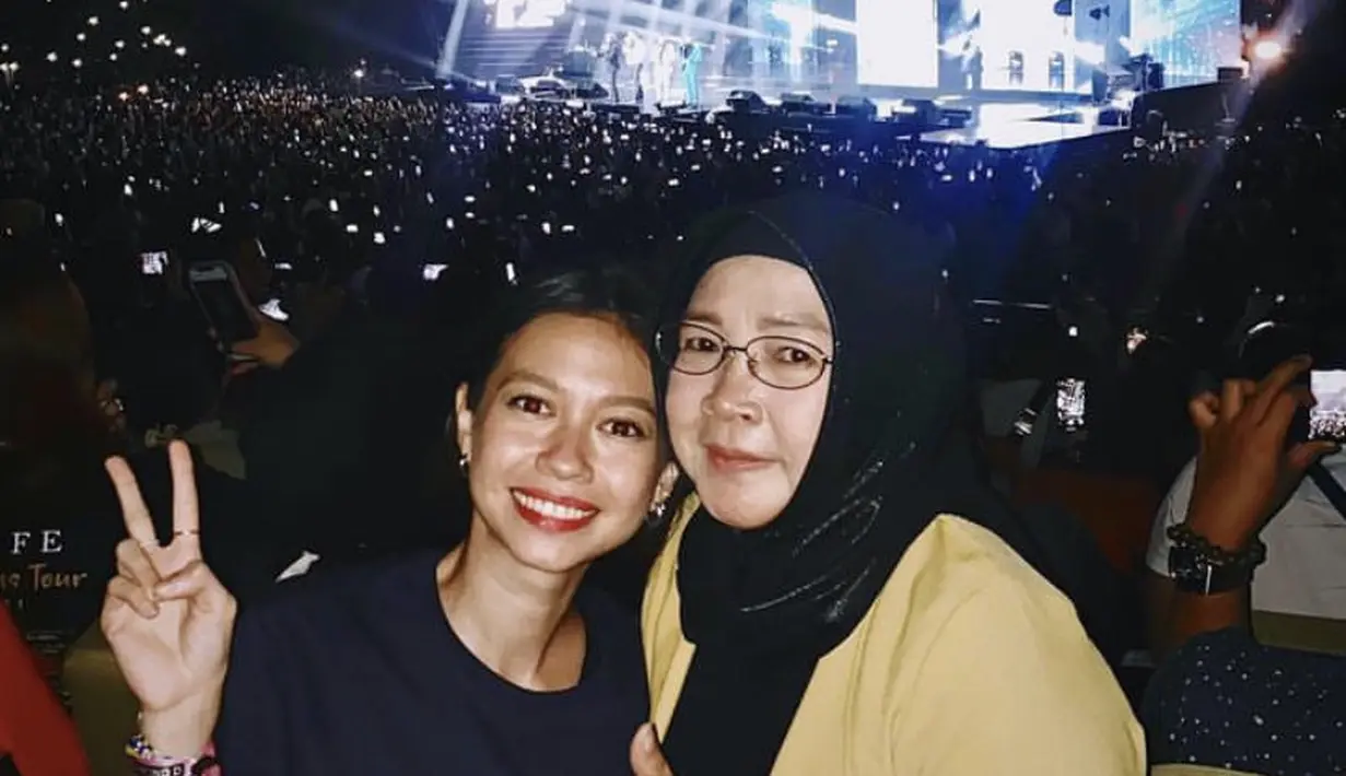 Saat menonton konser, Yuki mengenakan tshirt hitam Westlife. Lalu ibunda dengan baju kuning dan kerudung hitamnya. (@yukikt)