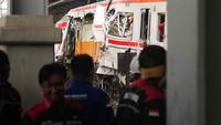 Para pekerja memeriksa kondisi lokomotif Kereta Api Jarak Jauh (KAJJ) Argo Bromo Anggrek dan salah satu gerbong Kereta Rel Listrik (KRL) Commuter Line yang mengalami kecelakaan di Stasiun Bekasi Timur, Bekasi, Jawa Barat, Selasa 28 April 2026. (AP Photo/Tatan Syuflana)