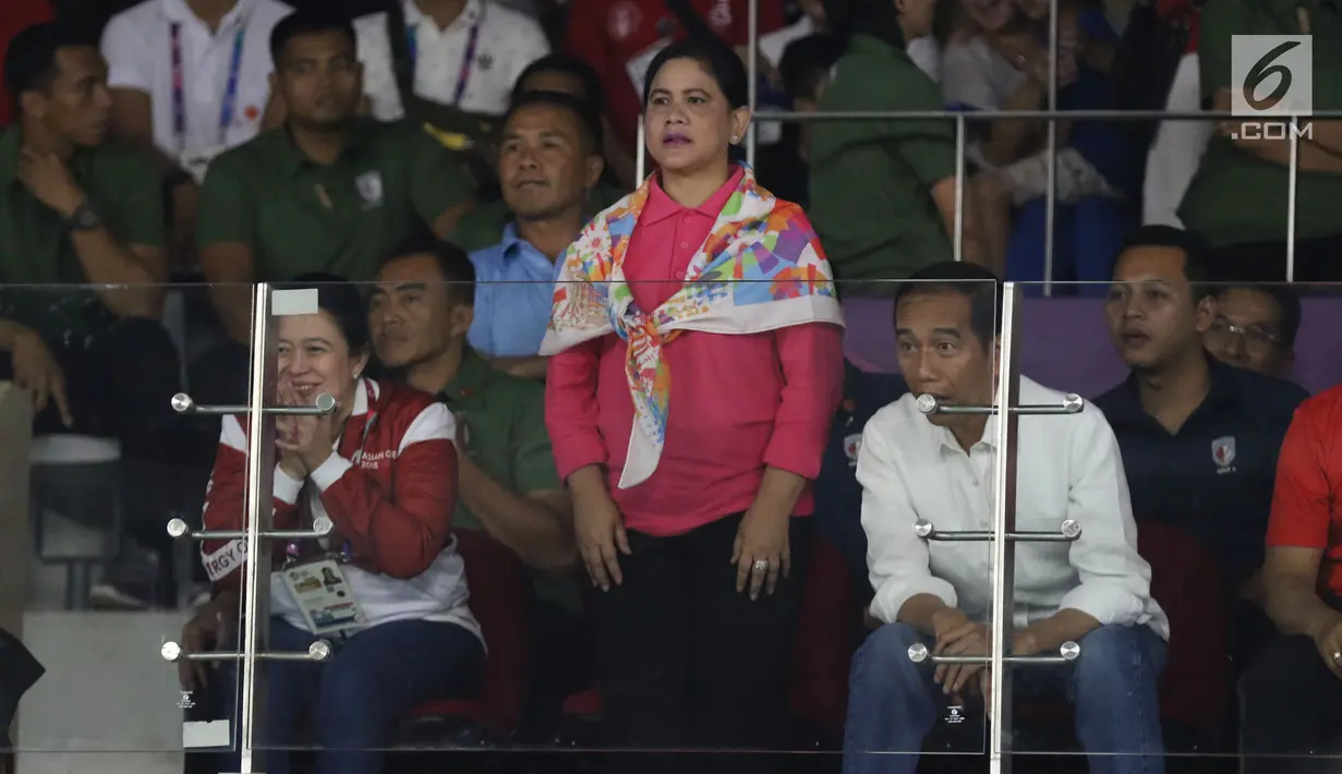 Ibu Negara, Iriana Joko Widodo (berdiri) saat menyaksikan laga final bulutangkis beregu putra Asian Games 2018 antara Indonesia melawan China di Istora Kompleks GBK, Jakarta, Rabu (22/8). Indonesia kalah dari China 1-3. (Liputan6.com/Helmi Fithriansyah)