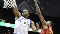 Pemain Warriors, Andre Iguodala #9 melakukan dunk saat diadang pemain Atlanta Hawks, Kent Bazemore pada laga NBA basketball game  di Philips Arena, Atlanta, (2/3/2018). Warriors menang 114-109. (AP/John Amis)