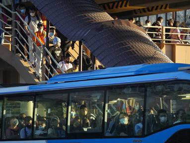 Komuter yang mengenakan masker menunggu kendaraan di halte bus di metro Manila, Filipina, Kamis (8/9/2022). Gugus Tugas Antar-Lembaga untuk Pengelolaan Penyakit Menular Filipina (IATF) menyarankan agar pemakaian masker di luar ruangan dapat dilakukan secara sukarela. (AP Photo/Aaron Favila)
