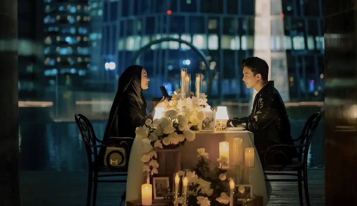 Pasangan ini pun tampil couple dengan pakaian serba hitam. Cocok dengan suasana romantis makan malam yang didekorasi dengan bunga dan lilin.  (@rey_mbayang)
