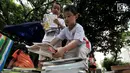 Anak-anak merapikan buku usai mengikuti program Literasi Kejujuran di Taman Bacaan Masyarakat (TBM) Saung Manggar, Pondok Kelapa, Jakarta, Minggu (24/3). (merdeka.com/Iqbal S. Nugroho)