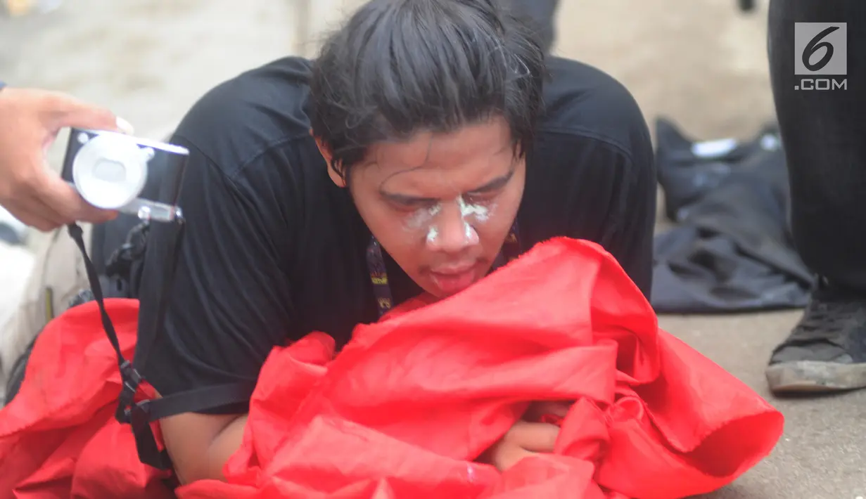 Jurnalis mengoleskan pasta gigi ke wajahnya saat demontrasi yang memanas di depan gedung DPR, Senayan, Jakarta, Selasa (24/9/2019). Polisi menembakkan gas air mata dan meriam air untuk membubarkan massa aksi yang menolak RKUHP dan RUU kontroversial lain. (merdeka.com/Arie Basuki)