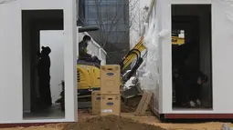 Pekerja memasang listrik di dalam kontainer untuk bangsal perawatan pasien corona COVID-19 di halaman Pusat Medis Seoul, Kamis (10/12/2020). Otoritas Korea Selatan membuat tempat tidur rumah sakit dari kontainer untuk meringankan beban fasilitas medis yang telah kewalahan. (AP Photo/Ahn Young-joon)