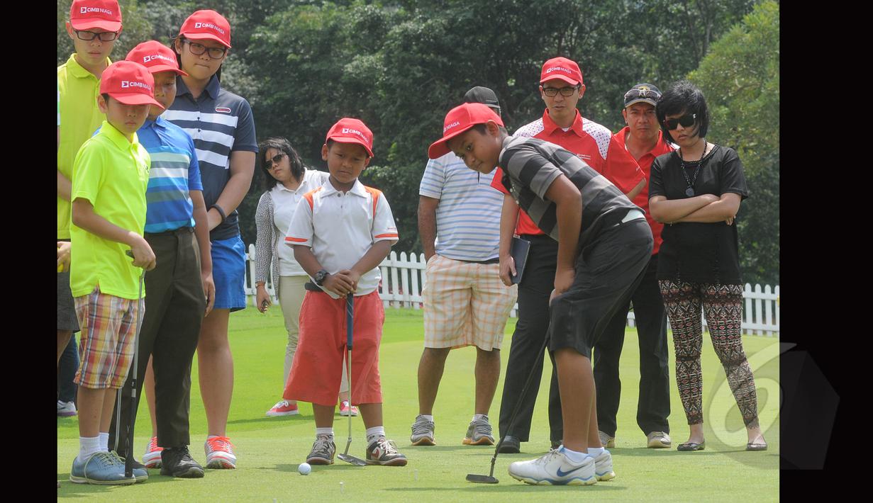 Seorang peserta mencoba memasukkan bola ke dalam lubang saat peserta ‘coaching clinik’ menyambut CIMB Niaga Indonesia Masters 2015 pada 23 April 2015, Jakarta, Minggu (15/3/2015). (Liputan6.com/Herman Zakharia)