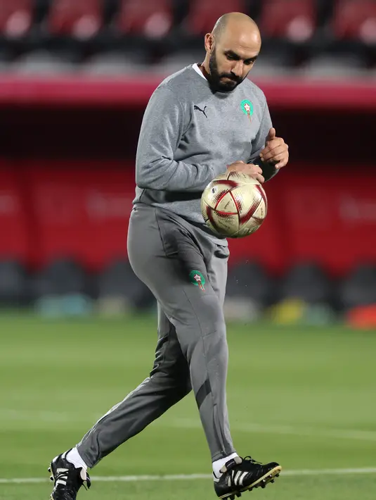 Pelatih Maroko Walid Reragui menggiring bola saat sesi latihan di Stadion Al Duhail SC di Doha (16/12/2022). Maroko akan bertanding melawan Kroasia untuk memperebutkan juara 3 Piala Dunia 2022. Keduanya dipertemukan kembali setelah pernah bertanding pada babak penyisihan grup F lalu. (AFP/Karim Jafaar)