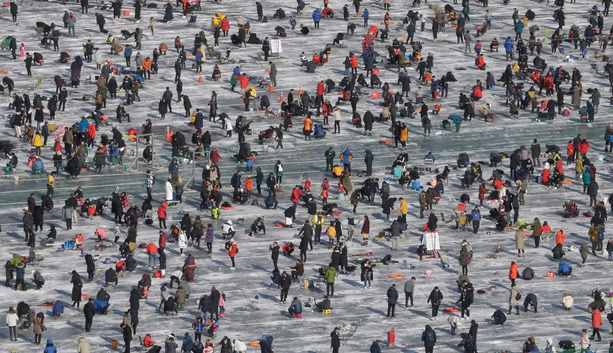 Peserta saat mengikuti lomba memancing ikan trout di sungai yang membeku di Hwacheon, Korea Selatan (6/1). Kontes ini merupakan bagian dari festival es tahunan yang menghasilkan lebih dari 1.000.000 pengunjung setiap tahunnya. (AP Photo/Ahn Young-joon)