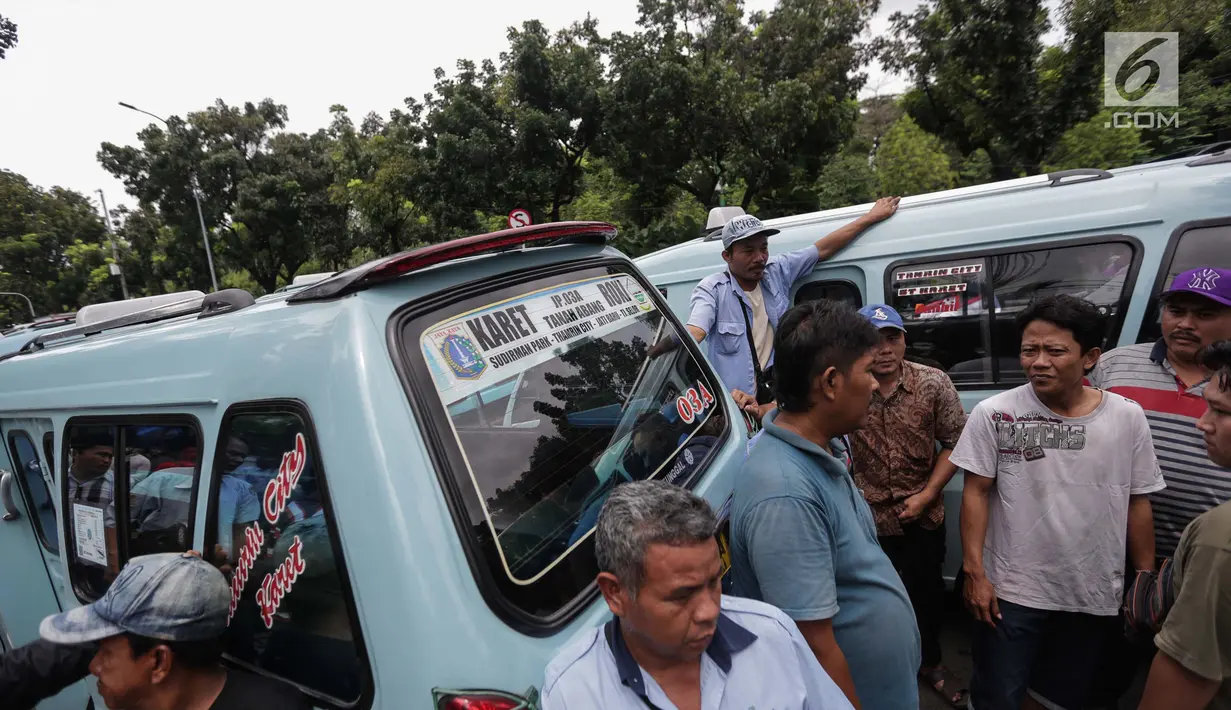 Para pengemudi angkutan memarkirkan mobilnya berkumpul untuk menggelar unjuk rasa di depan Balai Kota, Jakarta, Senin (22/1). Para sopir ini menuntut dibukanya jalan Jatibaru Raya dan putaran di depan Blok A Tanah Abang. (Liputan6.com/Faizal Fanani)