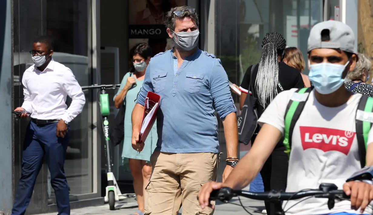 Orang-orang memakai masker saat berjalan di Brussel, Belgia, Rabu (12/8/2020). Penggunaan masker menjadi wajib di tempat umum di Brussel karena kasus Covid-19 naik ke tingkat kewaspadaan yang menempatkan kota itu di antara yang paling parah terkena dampak corona di Eropa. (François WALSCHAERTS/AFP)