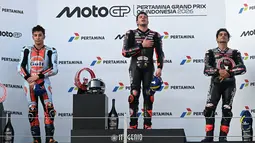 Pembalap Aprilia Racing asal Italia, Marco Bezzecchi (tengah), merayakan kemenangan di podium bersama runner-up Raul Fernandez dari Trackhouse MotoGP Team (kiri) dan Jorge Martin dari Aprilia Racing yang finis di posisi ketiga (kanan) setelah balapan MotoGP Indonesia di Sirkuit Internasional Mandalika, Mandalika, Minggu (11/10/2026). (SONNY TUMBELAKA/AFP)