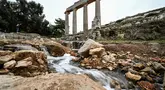 Air mengalir melalui reruntuhan di lokasi kota kuno Cyrene (Shahhat) Yunani-Romawi di Libya timur, sekitar 60(37 mil) barat Derna setelah banjir dahsyat, pada 21 September 2023. (Ozan KOSE / AFP)